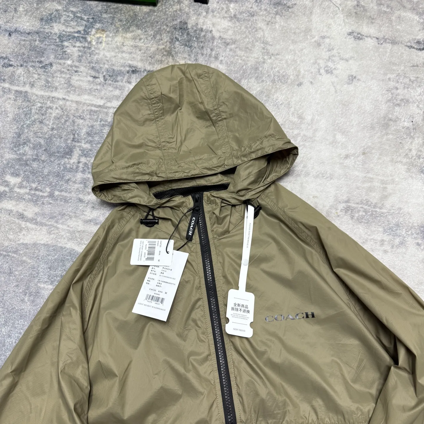 COACH solid color hooded lightweight outdoor men's jacket is a super lightweight sun protection jacket. The whole piece of clothing only weighs 3 grams. The upper body is as thin as a cicada's wings. The entire fabric is soft and has excellent skin fit. The upper body has a cool feeling, so even in the hot summer, it will not feel sticky or uncomfortable. The trading company ships the cabinets from the same fabric. There are only a few hundred pieces in this batch, so they are high quality. The fabric is a dark plaid fabric with a dark luster and texture. With a certain water-repellent design, it can well meet the needs of various scenes, whether commuting or outdoors. The zipper with Koujia letters is very smooth no matter how you pull it. The three-dimensional cut and split version makes the upper body very energetic, and the back is a separate version, which can better wick away sweat and ventilate. The Khaki color is casual Versatile, no matter how you wear it, you can't go wrong. The shopkeeper keeps the money for himself, no more misses. Absolutely good stuff! 🤗🤗🤗 Color: Khaki Size: M-XXL Size M: Length 69CM, bust 124CM, shoulder sleeves 79CM (reference weight: 115-135 catties) L size: length 71CM, bust 128CM, shoulder sleeves 81CM (reference weight: 135-150 catties) XL size: length 73CM, bust 132CM Shoulder sleeves 83CM (reference weight: 150-165 catties) XXL size: length 75CM, bust 136CM shoulder sleeves 85CM (reference weight: 165-180 catties)